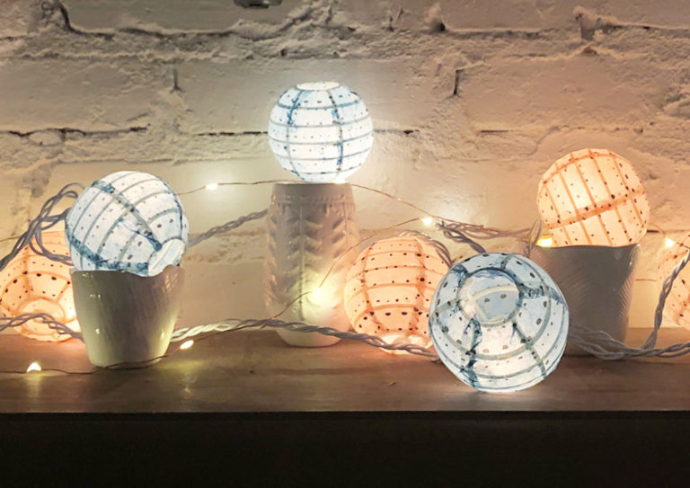 Unique gender reveal idea using string lights with paper globes // www.thehiveblog.com
